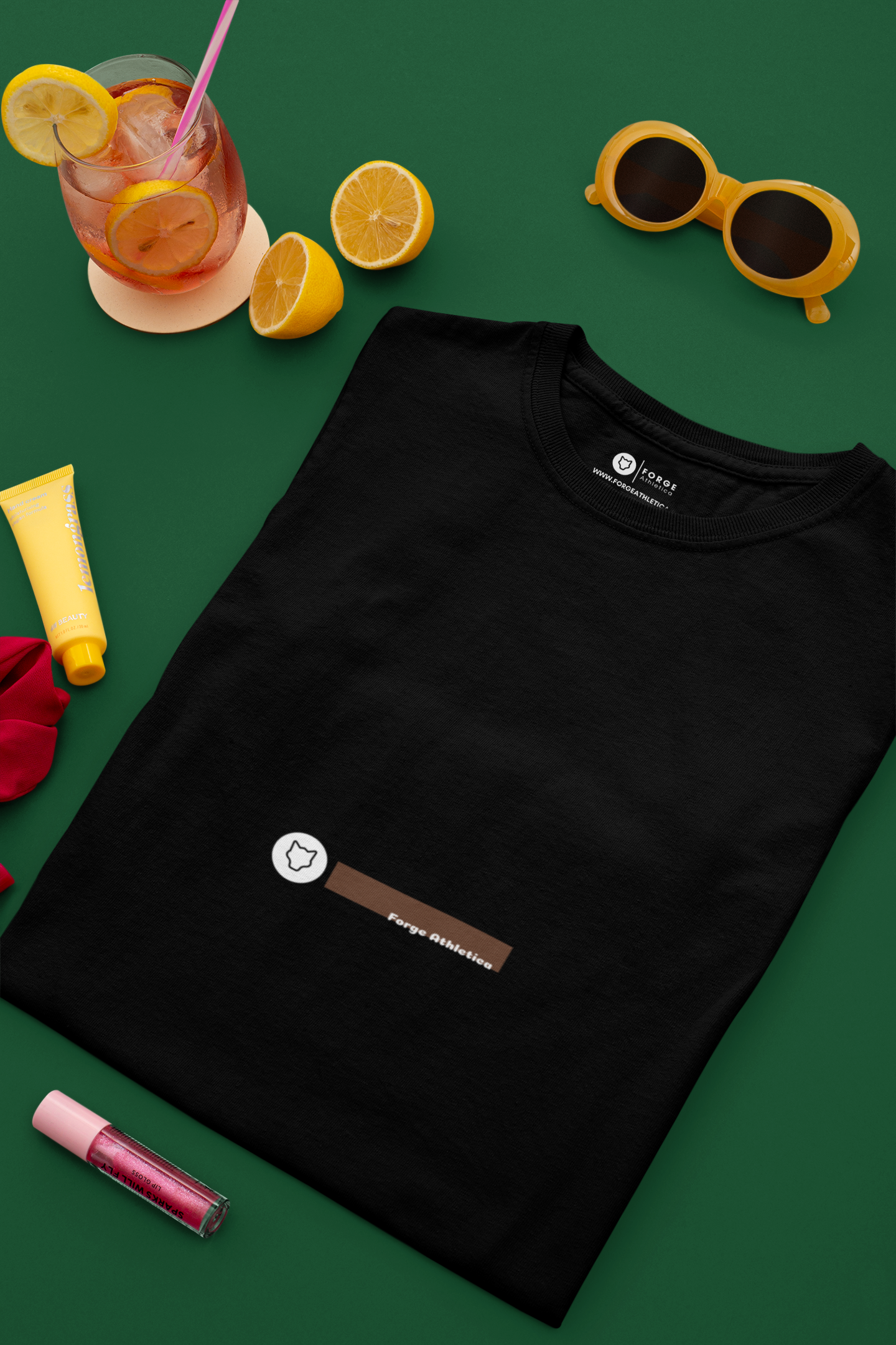 Premium 180GSM organic cotton T-Shirt folded and kept on a flat surface with yellow sunglasses, lip gloss and a glass of lemonade.